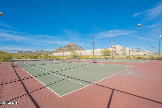 view of sport court with a mountain view and basketball hoop