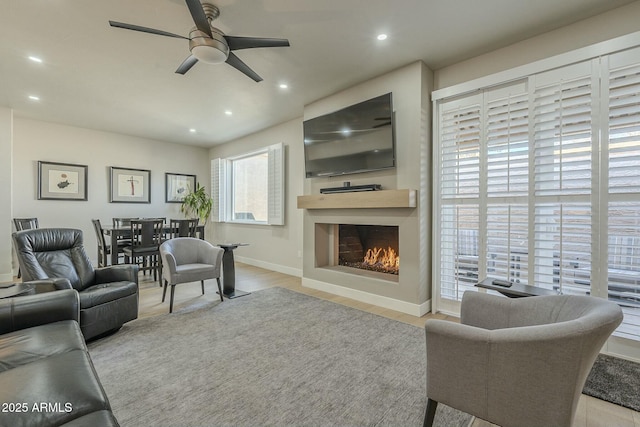 living room featuring ceiling fan and light hardwood / wood-style flooring