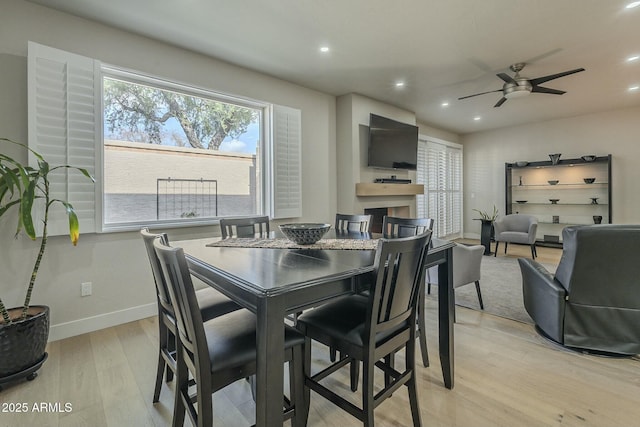 dining area with ceiling fan and light hardwood / wood-style flooring