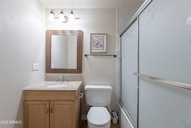 2233 W Farmdale Ave Unit 2, Mesa, AZ 85202 - full bathroom featuring a textured wall, vanity, combined bath / shower with glass door, and toilet