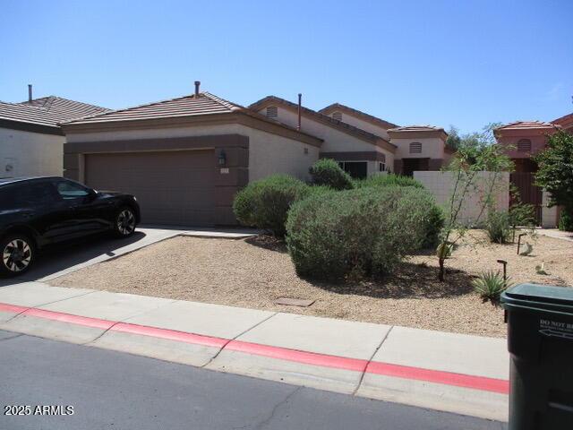 single story home with a garage, fence, stucco siding, a tiled roof, and driveway