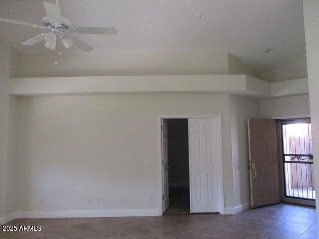unfurnished room featuring baseboards and ceiling fan