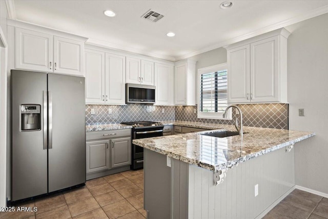 kitchen with light stone countertops, sink, white cabinetry, and stainless steel appliances