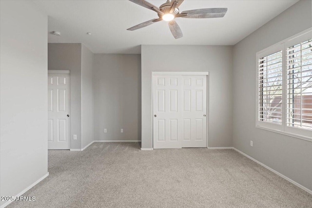 unfurnished bedroom with ceiling fan, a closet, and light colored carpet