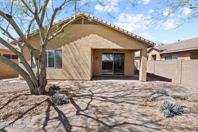 rear view of house featuring ceiling fan and a patio