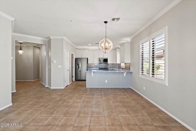 kitchen with kitchen peninsula, appliances with stainless steel finishes, backsplash, crown molding, and white cabinets