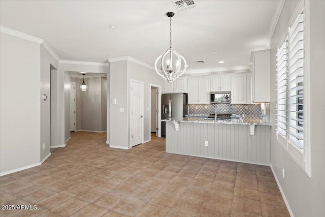 kitchen with light stone countertops, white cabinets, decorative light fixtures, stainless steel appliances, and kitchen peninsula