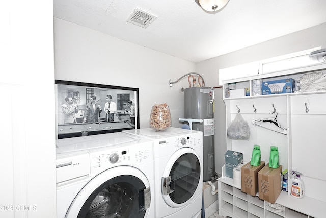 clothes washing area with electric water heater and independent washer and dryer