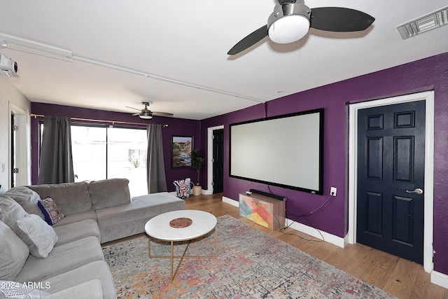 home theater featuring ceiling fan and light hardwood / wood-style floors