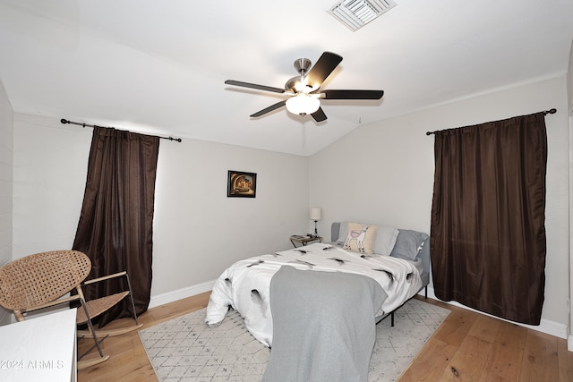 bedroom featuring ceiling fan, light hardwood / wood-style flooring, and lofted ceiling