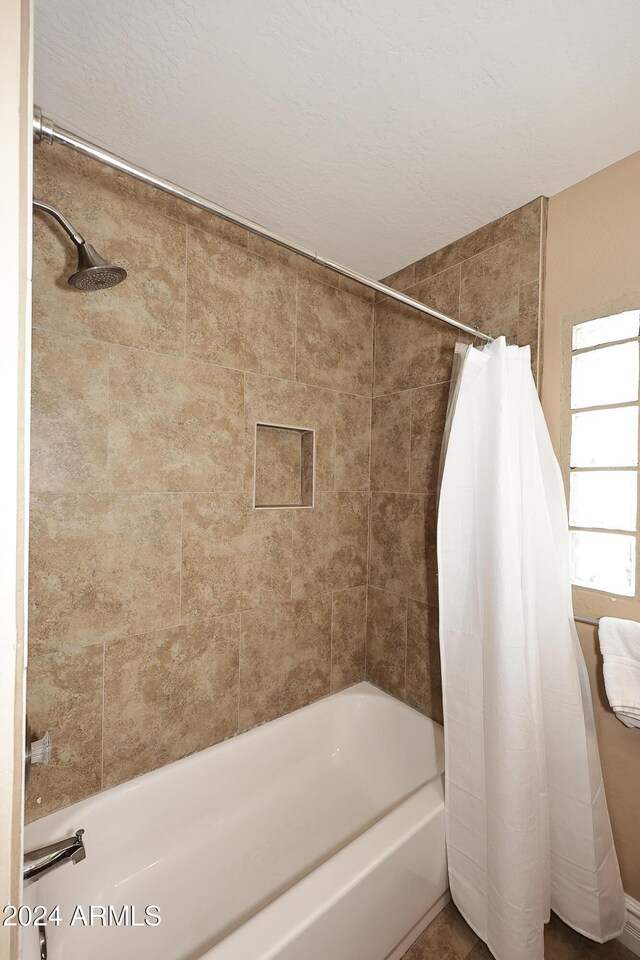 bathroom with shower / bathtub combination with curtain