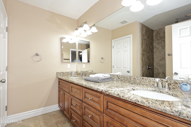 bathroom with tile patterned flooring, vanity, and walk in shower