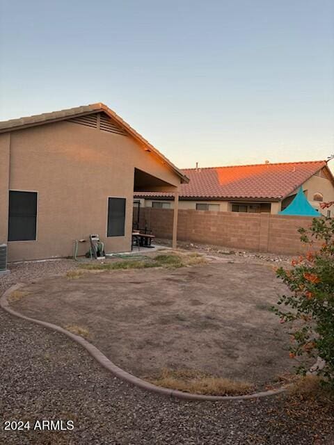 back house at dusk featuring a patio area