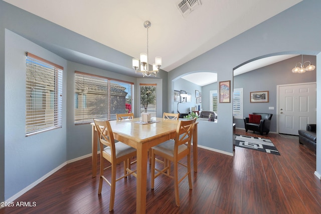 dining space with lofted ceiling, a notable chandelier, and dark hardwood / wood-style flooring