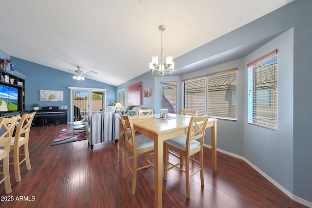 dining space with dark wood-type flooring, ceiling fan with notable chandelier, and vaulted ceiling