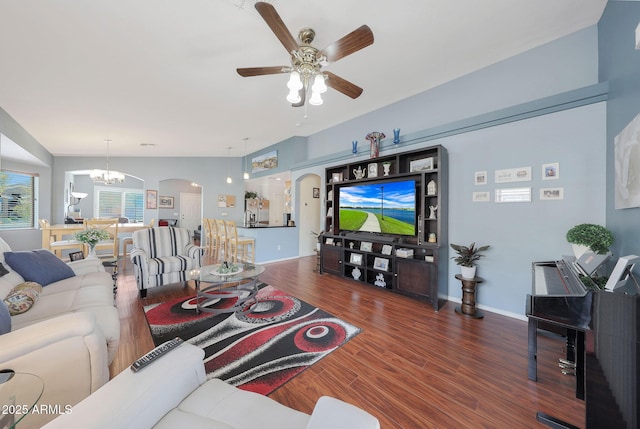 living room featuring ceiling fan with notable chandelier and dark hardwood / wood-style flooring