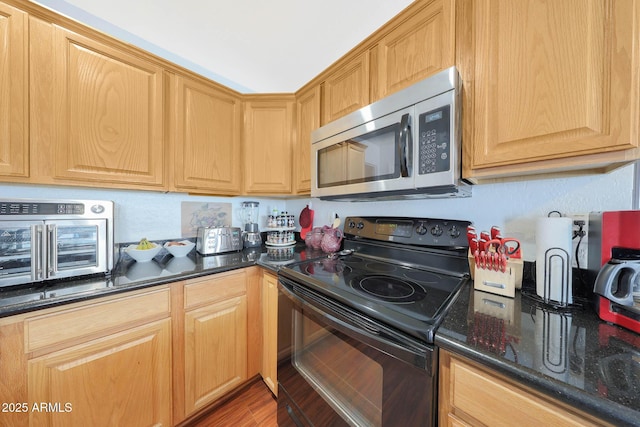 kitchen with wood-type flooring, dark stone counters, and black / electric stove