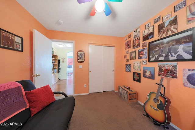 sitting room with ceiling fan and carpet