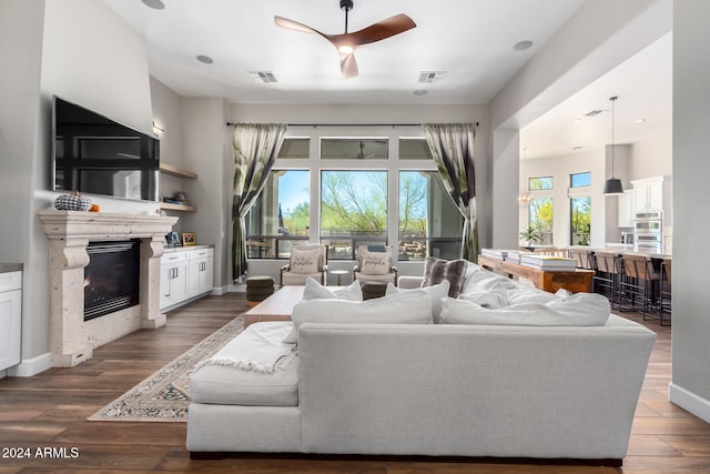 living room with ceiling fan, a fireplace, and hardwood / wood-style floors