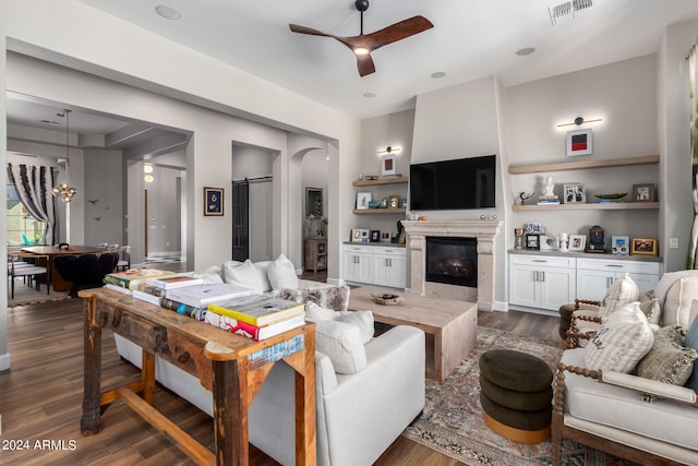 living room featuring a barn door, dark wood-type flooring, and ceiling fan