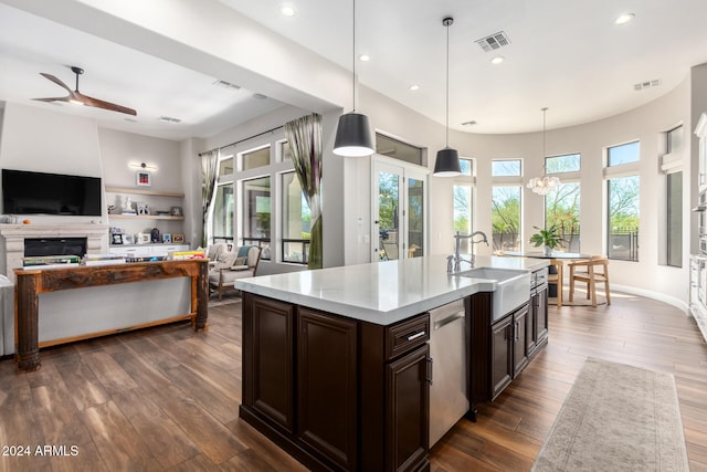 kitchen with dark hardwood / wood-style floors, dark brown cabinetry, decorative light fixtures, and sink