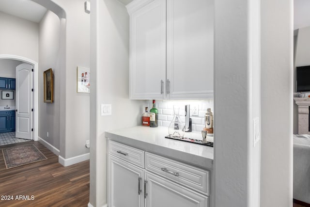 bar featuring decorative backsplash, white cabinets, and dark hardwood / wood-style floors