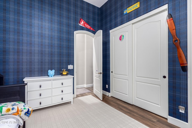 bedroom with wood-type flooring and a closet