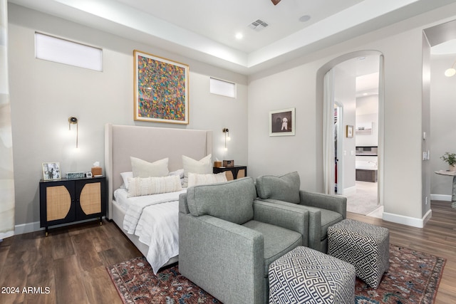 bedroom with ensuite bath and dark hardwood / wood-style flooring