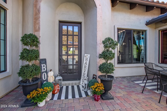 view of exterior entry featuring a patio area