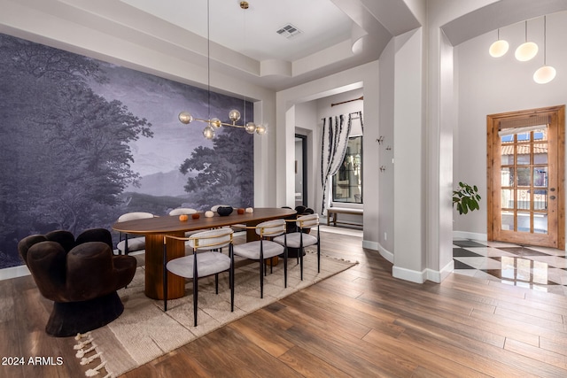 dining area featuring hardwood / wood-style flooring and a tray ceiling