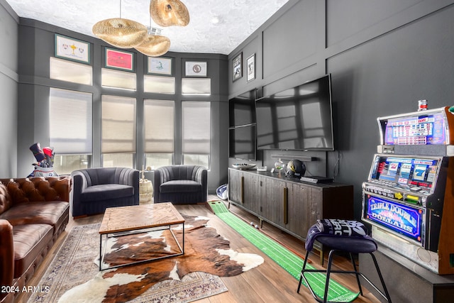 living room featuring crown molding, wood-type flooring, and a textured ceiling