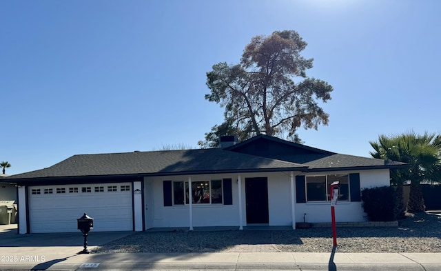 ranch-style home with a chimney, stucco siding, driveway, and an attached garage