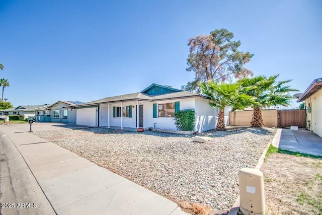 single story home featuring stucco siding, concrete driveway, an attached garage, and fence