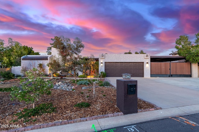 view of front of home featuring a garage, driveway, and stucco siding