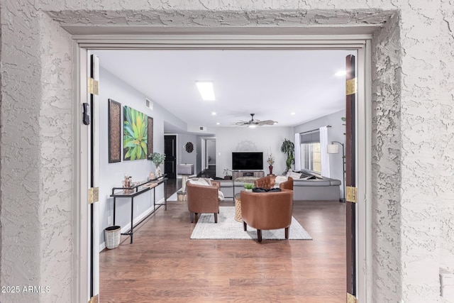 living room featuring a ceiling fan, wood finished floors, and visible vents