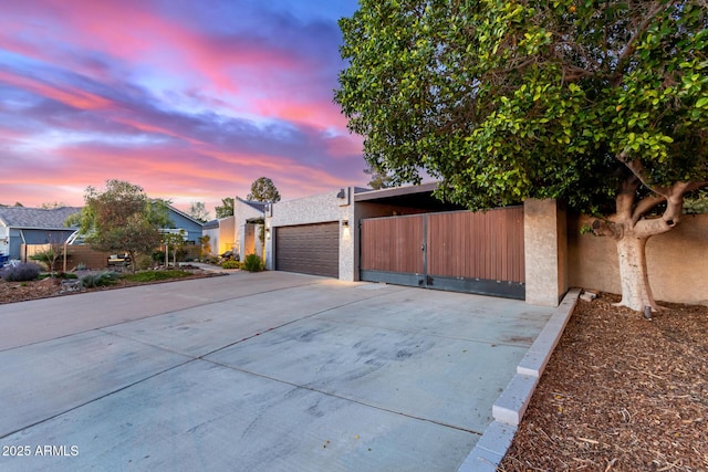 view of front of home with stucco siding, an attached garage, and concrete driveway