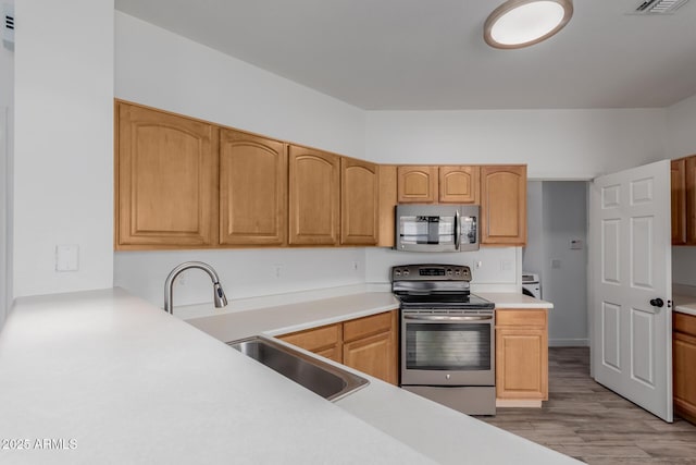2326 E Spruce Dr, Chandler, AZ 85286 - kitchen with stainless steel appliances, a sink, light wood finished floors, and light countertops