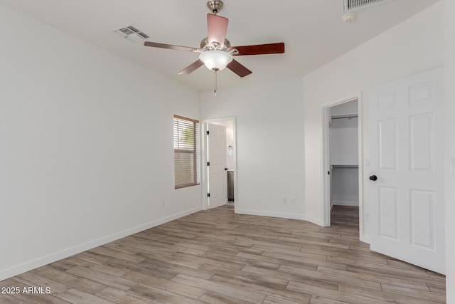 2326 E Spruce Dr, Chandler, AZ 85286 - unfurnished bedroom with a spacious closet, light wood-type flooring, baseboards, a closet, and a ceiling fan
