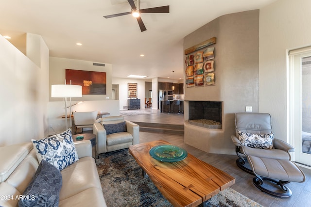 living room featuring hardwood / wood-style flooring, ceiling fan, and a multi sided fireplace