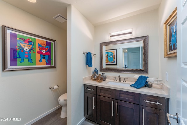 bathroom featuring vanity, hardwood / wood-style flooring, and toilet