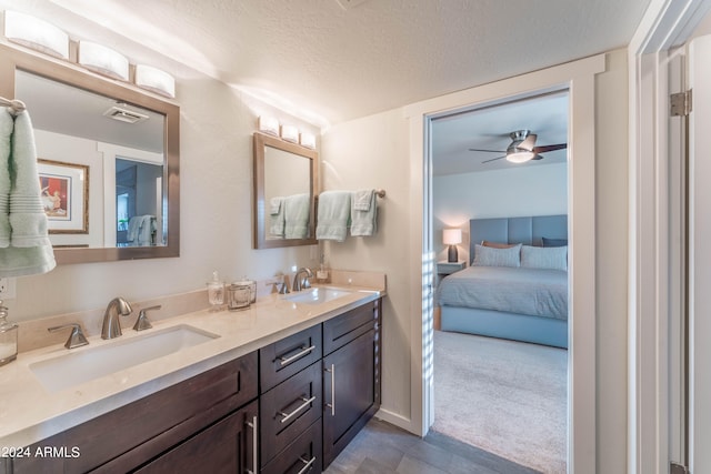 bathroom with vanity, ceiling fan, and a textured ceiling