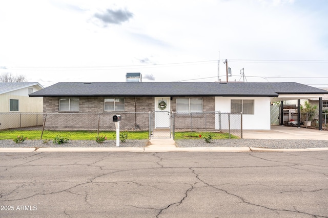 view of front of house with a fenced front yard, roof with shingles, a gate, and a carport