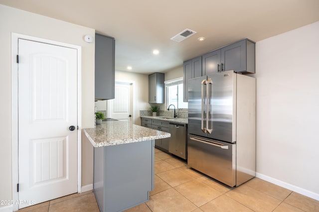 kitchen with visible vents, appliances with stainless steel finishes, gray cabinetry, and a sink