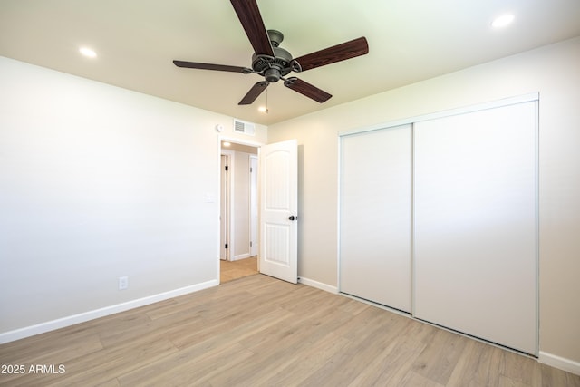 unfurnished bedroom with visible vents, light wood-type flooring, and baseboards