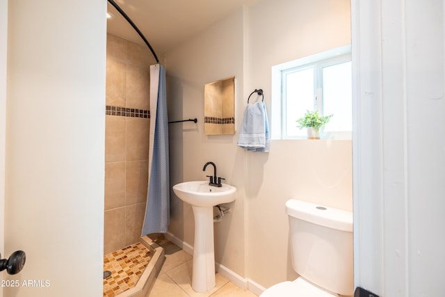 full bathroom with baseboards, a stall shower, a sink, tile patterned flooring, and toilet