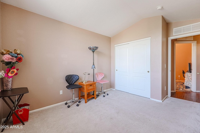 sitting room featuring light colored carpet and vaulted ceiling