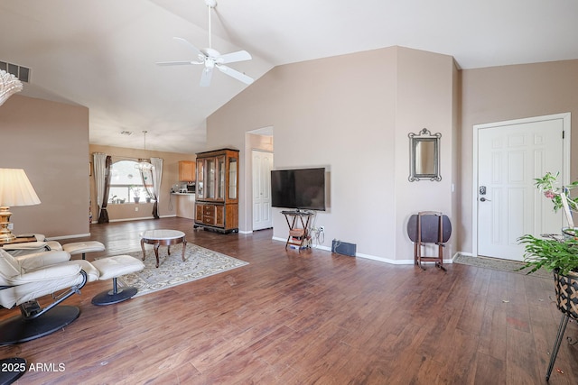 living room featuring dark hardwood / wood-style flooring, vaulted ceiling, and ceiling fan