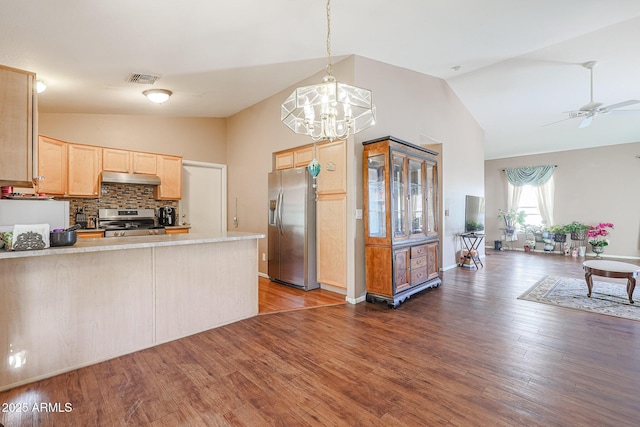 kitchen with dark wood-type flooring, stainless steel appliances, tasteful backsplash, kitchen peninsula, and light brown cabinetry