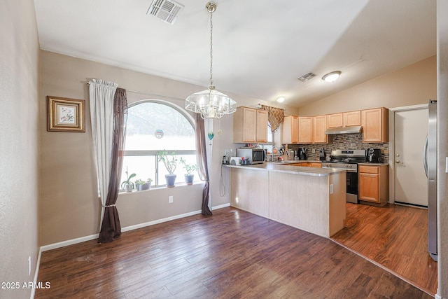 kitchen featuring kitchen peninsula, appliances with stainless steel finishes, dark wood-type flooring, decorative light fixtures, and lofted ceiling