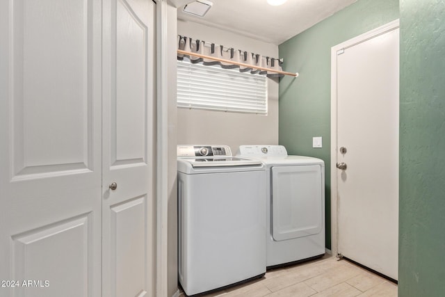 laundry area with washer and dryer and light hardwood / wood-style floors